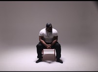 a man sitting on a chair in a studio